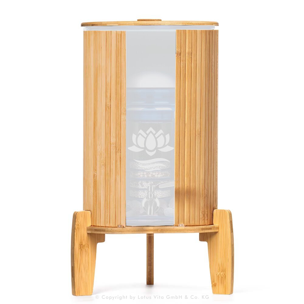 Ein Stand-Wasserfilter mit 8 Litern Fassungsvermögen, umhüllt von einem Lichtschutz aus Bambus, stehend auf einem passenden Bambussockel.