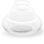 Detailaufnahme des Bodens einer wellenförmigen Glaskaraffe, in den das Symbol der Blume des Lebens in Platin eingearbeitet ist.