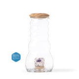 Mundgeblasene Glas-Karaffe mit gewelltem Design, einem Deckel aus Olivenholz und einem integrierten Fach mit Amethyst- und Rosenquarz-Edelsteinen.