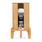 Ein Glas-Wasserfilter von Lotus Vita, auf einem Bambus-Standfuß stehend und ausgestattet mit einem Bambus-Deckel sowie einem passenden Lichtschutz aus Bambus.